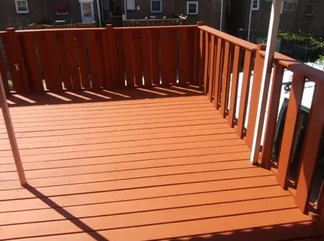 Top of an elevated red-painted deck with new railings