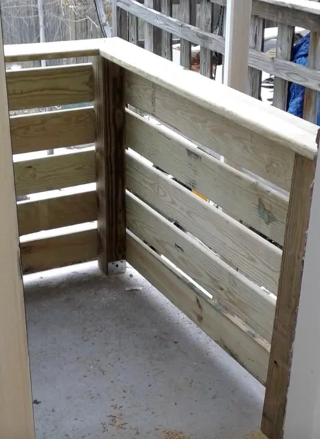 New pressure-treated wood privacy railing on a porch