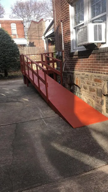 Long wheelchair accessibility ramp leading to a back door